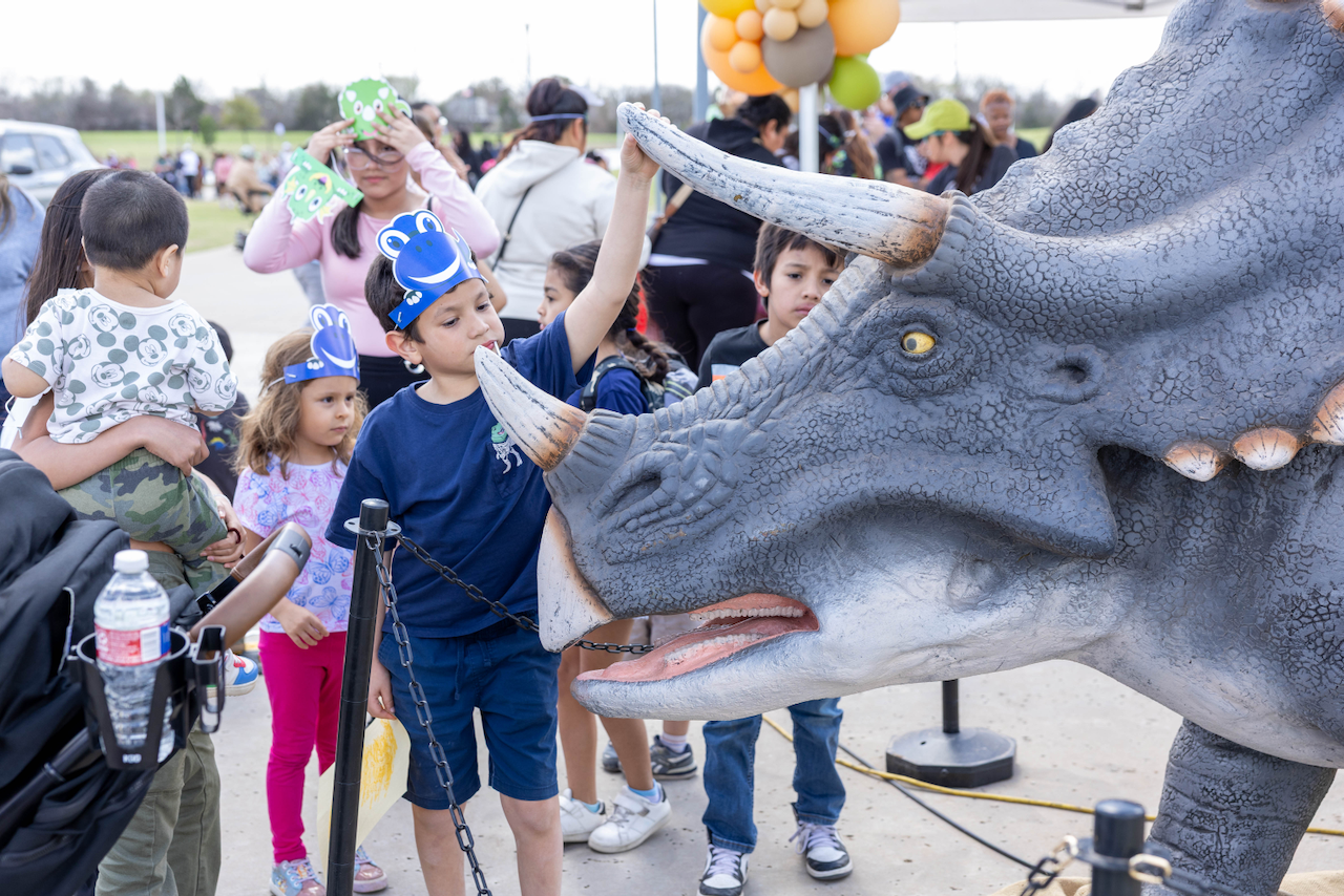 A child gets up close and personal with a triceratops